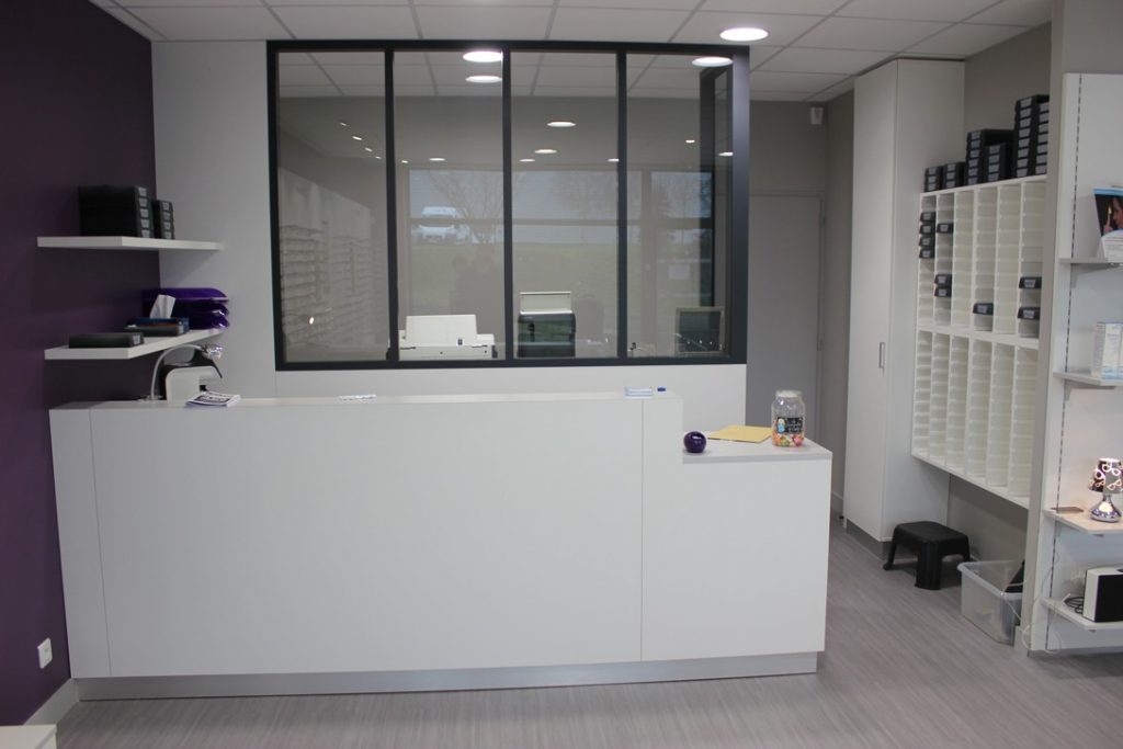 Agencement sur mesure de l'espace paiement avec vue sur l'atelier