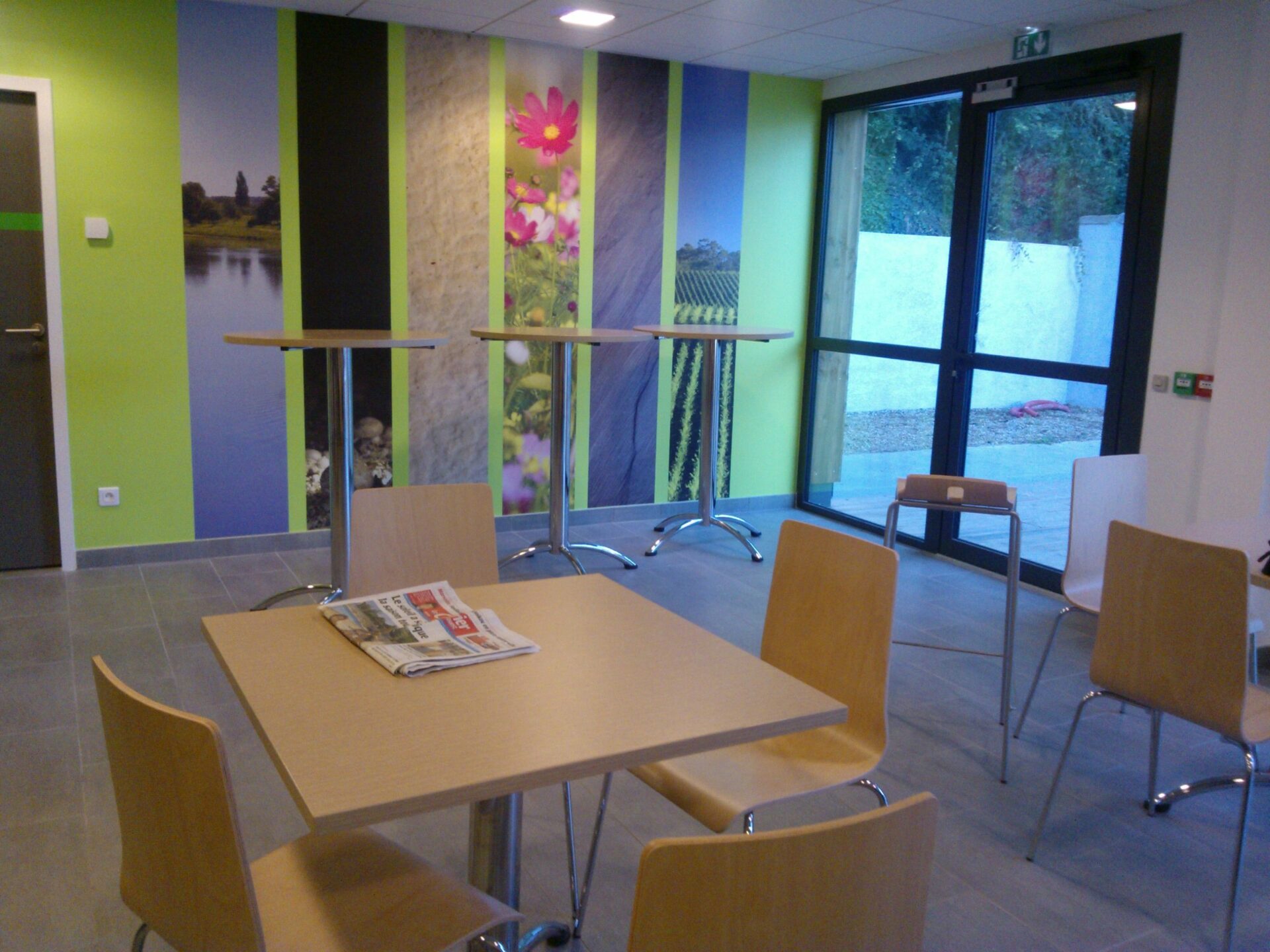Aménagement d'une salle de pause avec des tables et mange debout