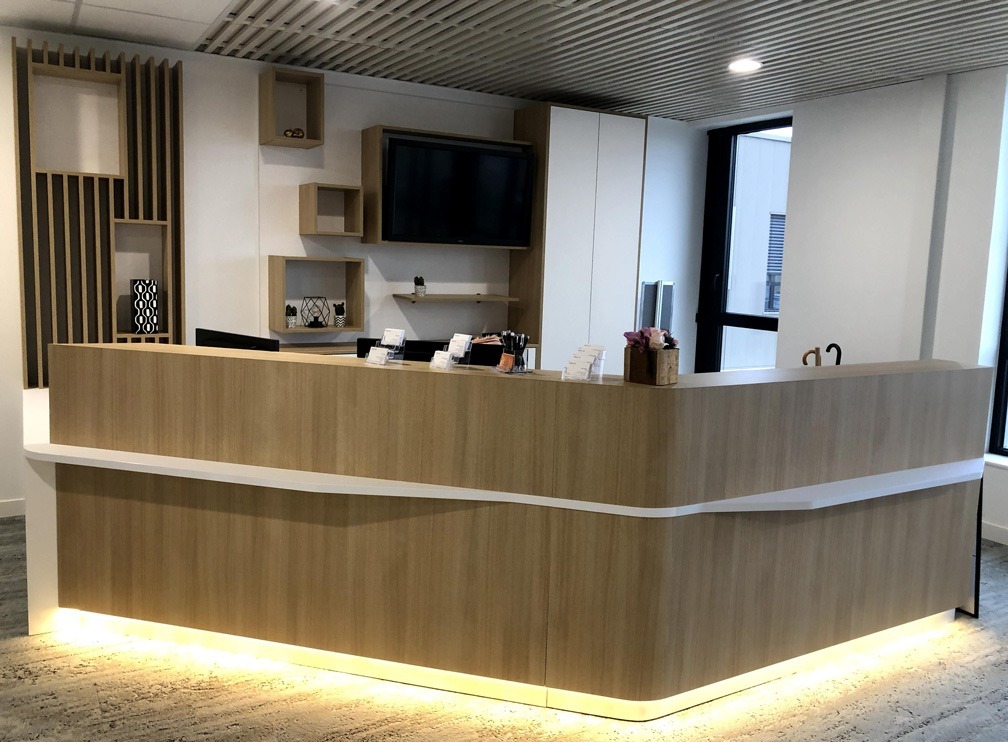 Aménagement d'une banque d'accueil sur mesure avec éclairage intégré pour une banque